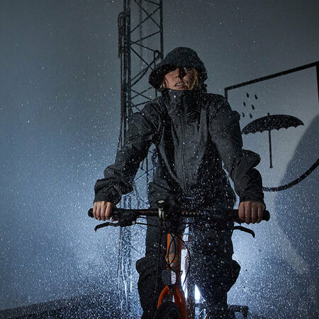 Kvinna cyklar i regnkammare