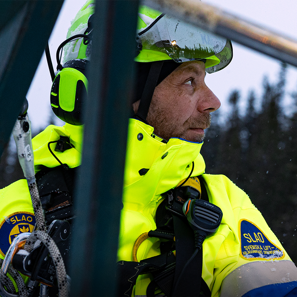Woman wearing a Taiga cap next to a helicopter